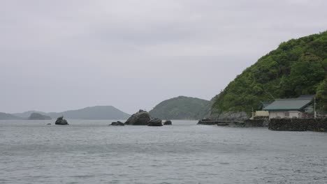 mie coastline in foul weather, meoto iwa wedded rocks in background 4k