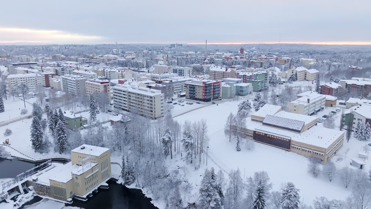 Aerial tracking shot in front of the library and the snowy Kajaani city, Finland