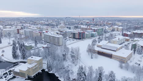 aerial tracking shot in front of the library and the snowy kajaani city, finland