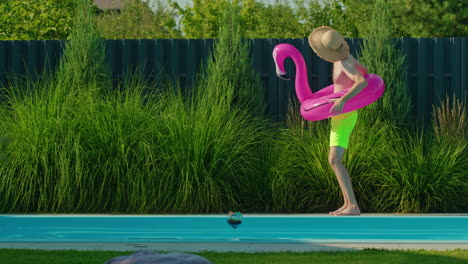 hombre divirtiéndose en la piscina con un flamenco inflable