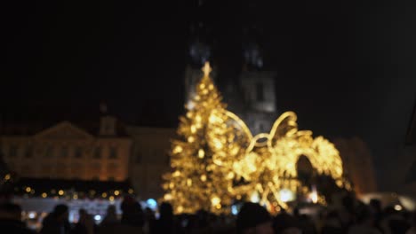 christmas markets in prague city, tree lights and crowds of people, soft focus view