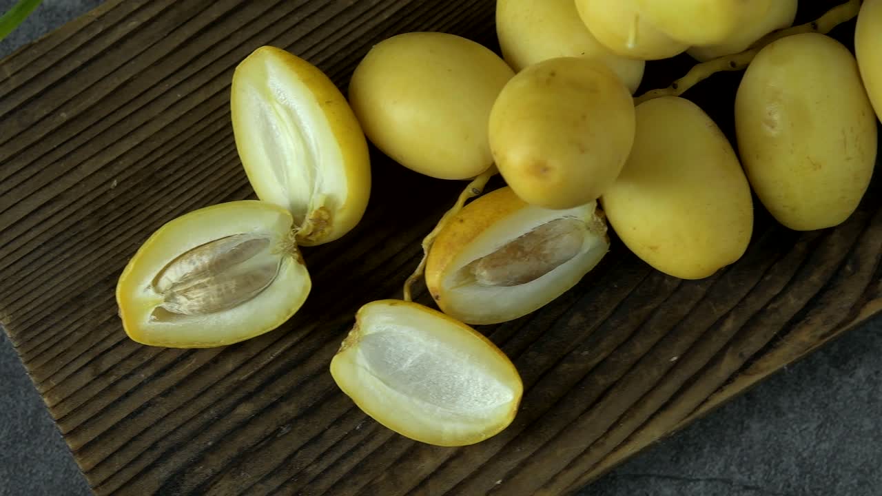las palmeras de dátiles frescas se colocan en la mesa con aceite, concepto de alimentos saludables. palmeras de dátils. frutas crudas de palmieras de dátiles (phoenix dactylifera)