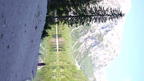 Mujer-Quitando-El-Sombrero-En-La-Orilla-Del-Lago-Di-Braies-Contemplando-El-Bosque