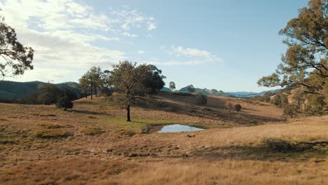 Slow-paced-forward-aerial-tracking-shot-over-a-small-dam-in-beautiful-Australian-scenery