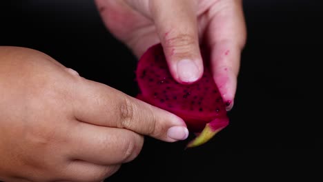 manos pelando y examinando rebanadas de frutas de dragón