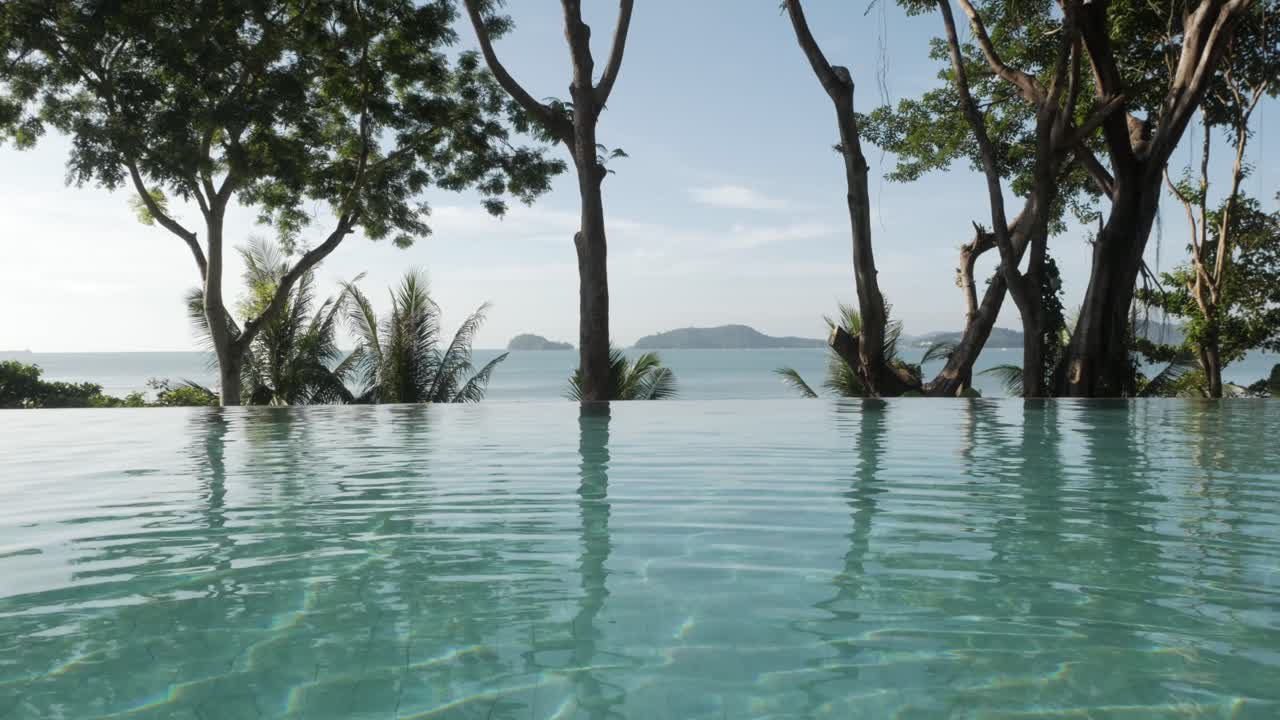 自然の海と木のある山の景色を背景にした無限のスイミングプール
