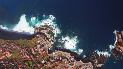 waves crashing into cliffs shores of porto moniz, madeira island, portugal