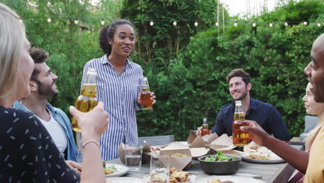 friends making toast with alcohol in garden at home enjoying summer garden party