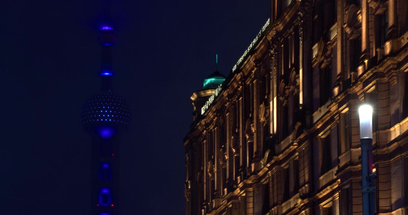 Edificio storico illuminato e Torre della Perla d'Oriente a Shanghai di notte
