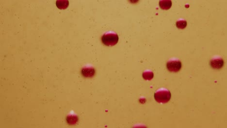 burbujas de tinta rosa que se hunden lentamente en el aceite cerca de tiro estático