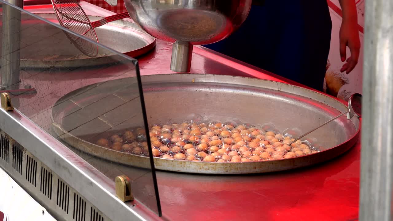 sweet doughnuts bake in special dish with hot oil and baker hand mix. 4K