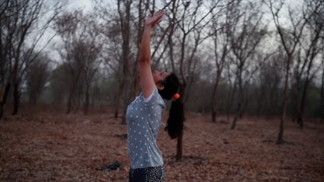 Mujer-Joven-Haciendo-Yoga-En-Un-Parque-Cerca-De-Un-Río-Durante-La-Mañana,-Destello-De-Lente-Y-Hermoso-Fondo-De-Vista