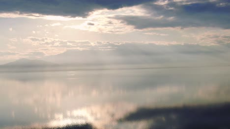 salt lake reflecting sun and clouds, symmetry aesthetic aerial landscape zoom in, sunny weather, pretty cloud, shot in salton sea