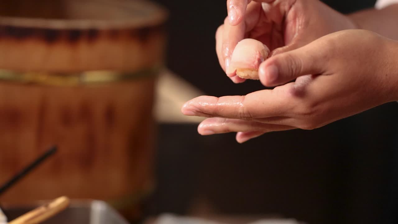 Close-up of a chef's hands expertly pressing rice and raw fish into nigiri sushi