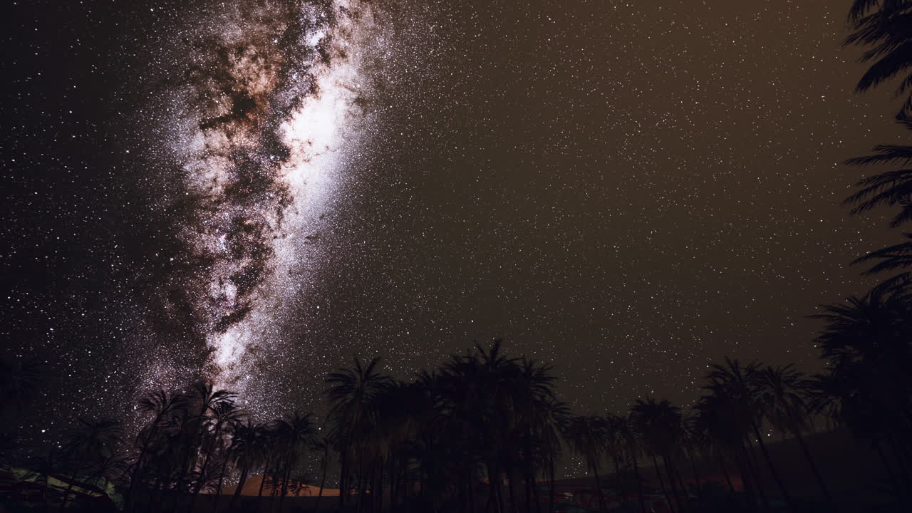 Night scene with silhouette hut and coconut tree with Milky Way Galaxy in sky