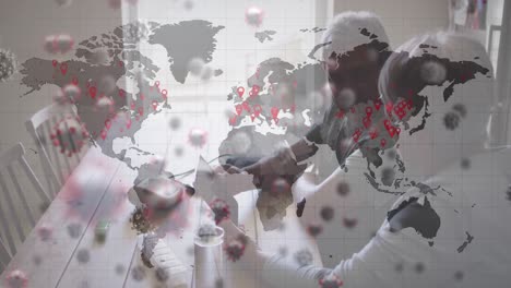 animación de datos financieros y células de virus sobre una pareja de ancianos biracial usando una tableta en casa