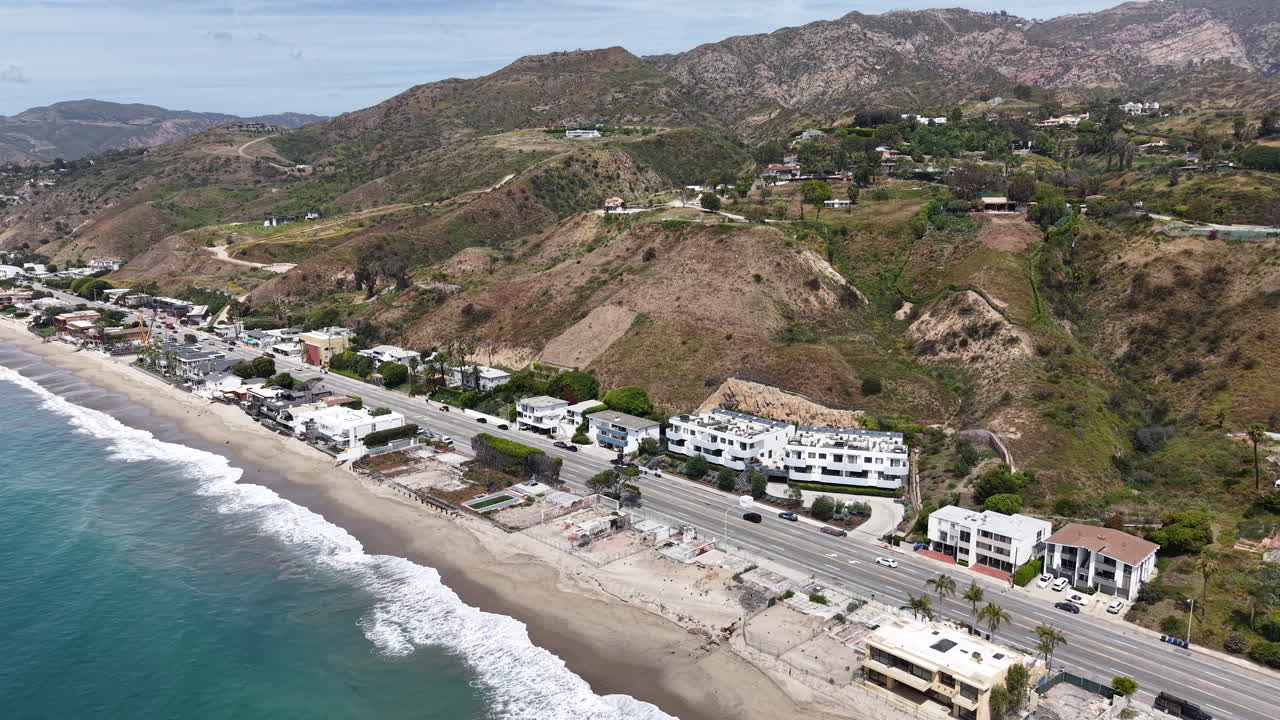 Riprese aeree cinematografiche diurne con drone catturate su Malibu, con un lento movimento discendente dalla costa verso la Pacific Coast Highway