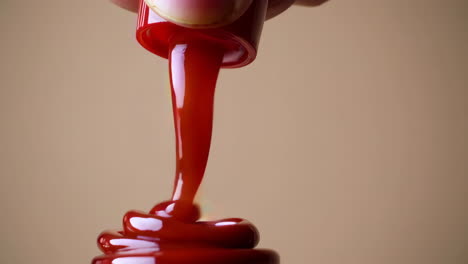 hand pouring red sauce from bottle