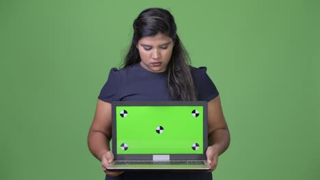 joven sobrepeso hermosa mujer de negocios india contra fondo verde