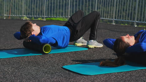 couple foam rolling outdoor workout