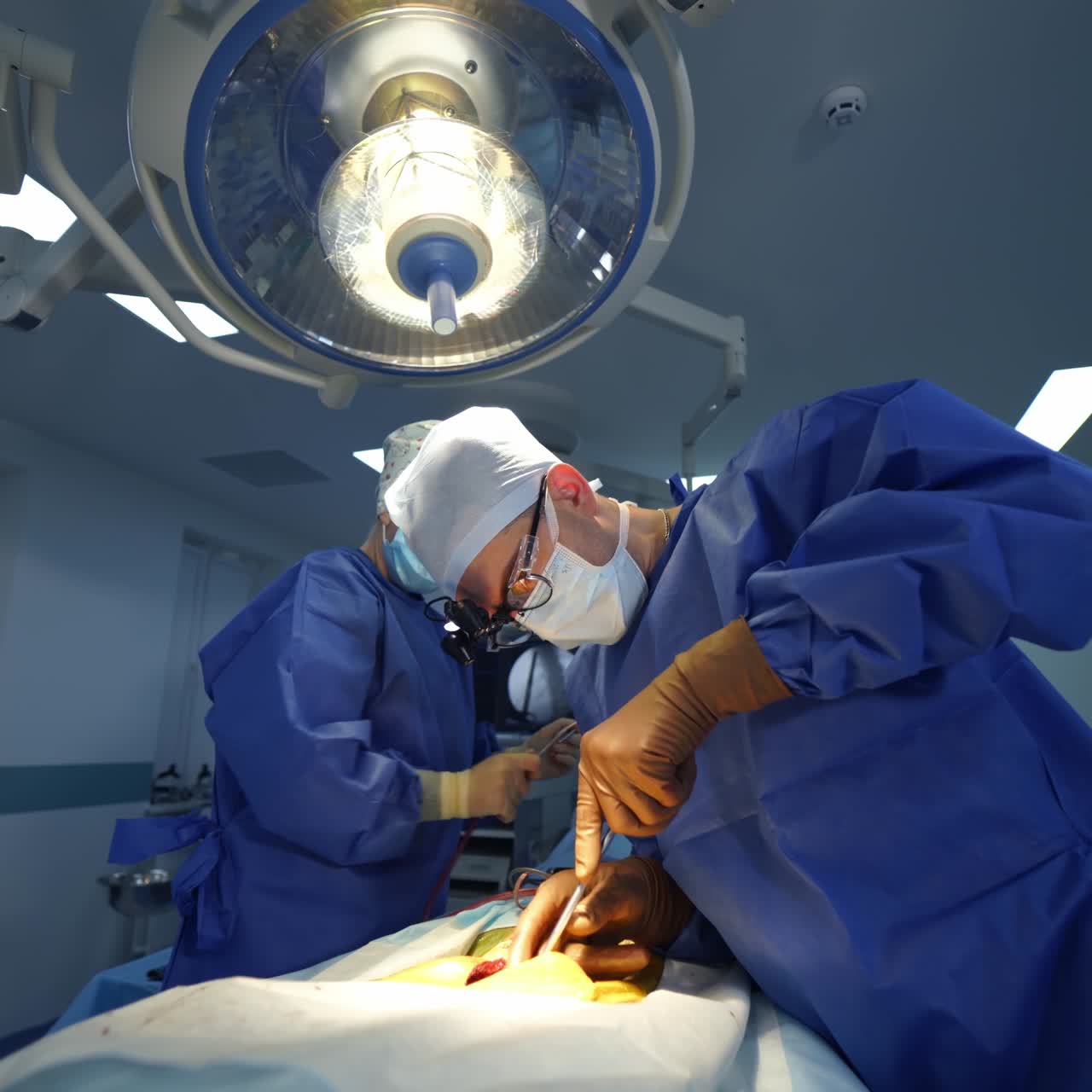 Surgical process by specialists. Professional doctor and assistant conduct a spinal surgery using surgical equipment in operating room