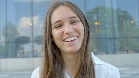 mujer caucásica elegante, sonriendo directamente a la cámara, vista de cerca