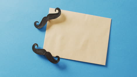 video de dos bigotes falsos y un sobre amarillo con espacio de copia sobre un fondo azul