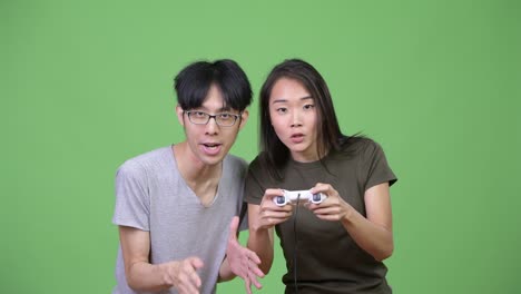 young asian couple playing games together