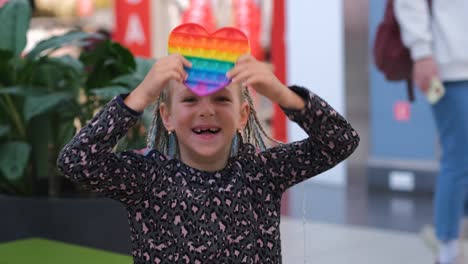 little girl having fun with fidget toy in mall