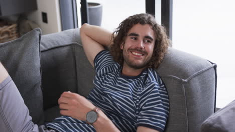 young caucasian man relaxes comfortably on a sofa at home