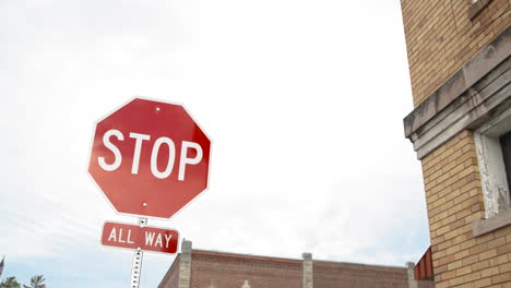 Señal-De-Stop-Roja-Todo-El-Camino-Cerca-Del-Edificio-De-Ladrillo