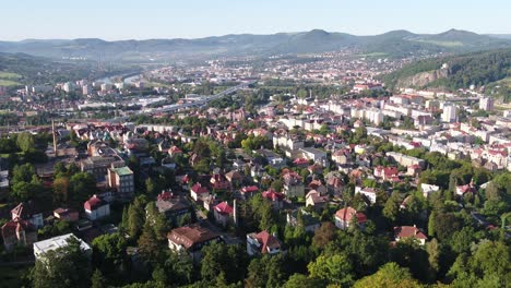 a cinematic semi orbit around a white historic mansion on a hill surrounded by lush forest in decin