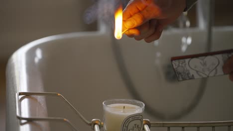 Lighting candle in bath with running water
