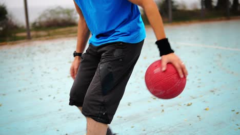 Kamerarundfahrt:-Junger-Mann-übt-Draußen-Basketball.-Zeitlupenaufnahme