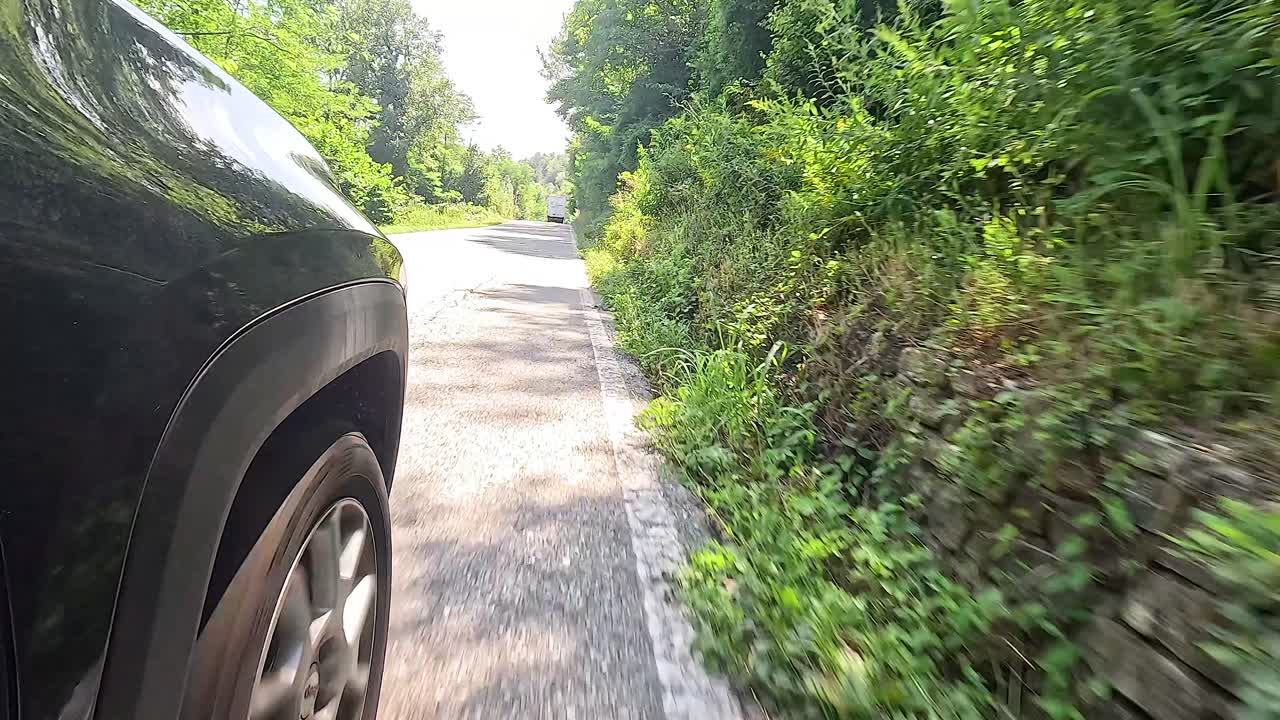 conduciendo en coche a través de un campo exuberante y verde en piamonte, italia