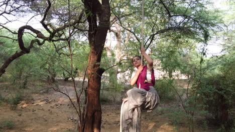 a sporty gymnast performs exercises with a rope in indian traditional wear