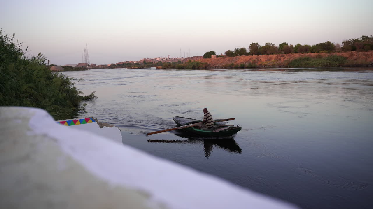 río nilo egipto agricultor local remando durante la puesta de sol con un barco tradicional de madera hecho a mano