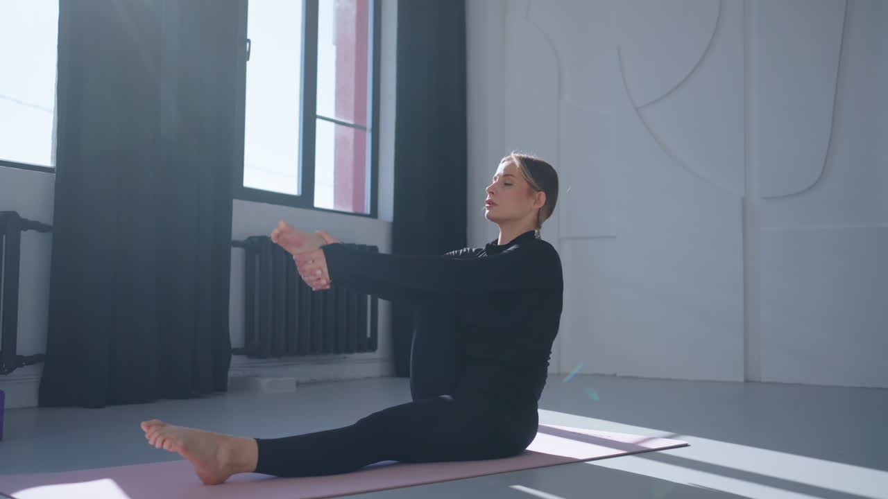 mujer haciendo estiramientos de yoga en un estudio