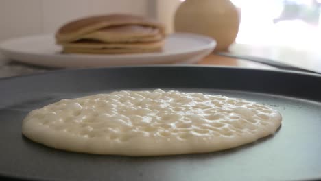 Close-up-of-a-pancake-being-cooked-for-breakfast-with-bubbles-forming