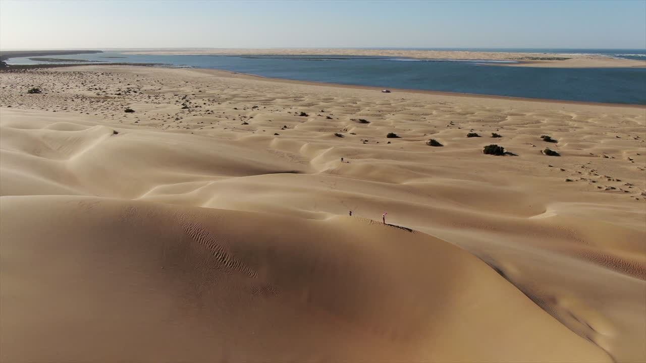 sobrevuelo de dunas y vista sobre el horizonte de la laguna naila ubicada en la provincia de tarfaya, sahara, marruecos