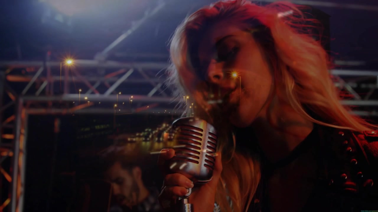 Female singer singing into stage mic closeup opening showing music city lights overlay player back