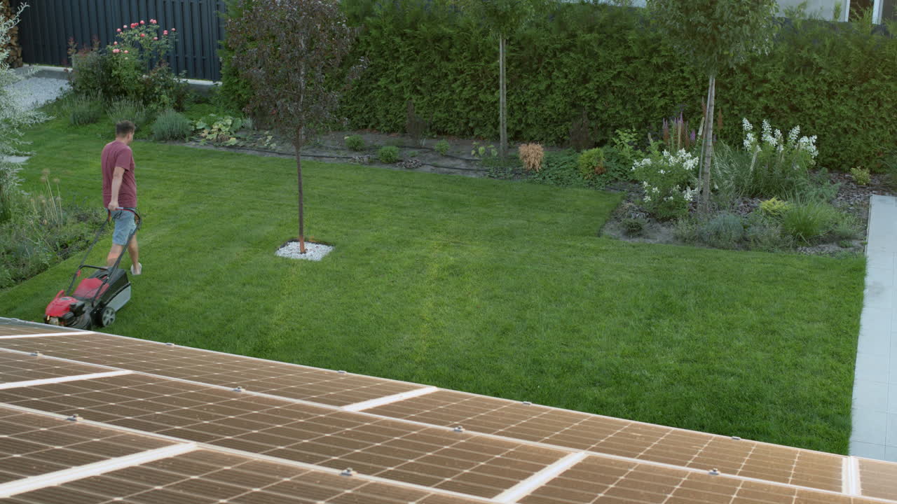 Man mowing the lawn in the backyard of the house, top view. Timelapse video
