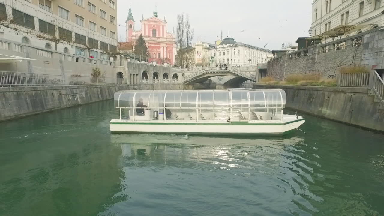 Little touristic boat cruise on its usual route over river Ljubljanica in Ljubljana, Slovenia.