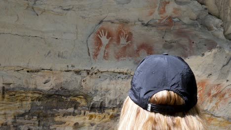 women viewing the ancient culture of aboriginal storytime rock art cave paintings from indigenous australian first nation people