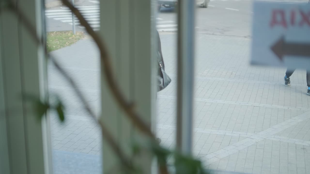 검은색 의상을 입은 전문적인 여성 관리자가 사무실을 걸어다니며 동료들과 상호 작용하며 문서와 노트북을 들고 리더십과 전문성을 보여주고 있습니다.