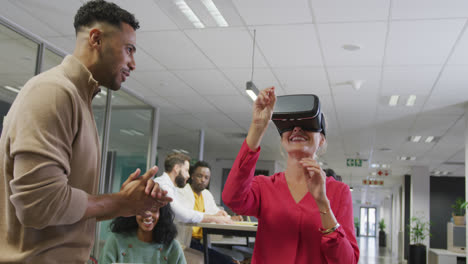 Happy diverse male and female business colleagues using vr headset in office