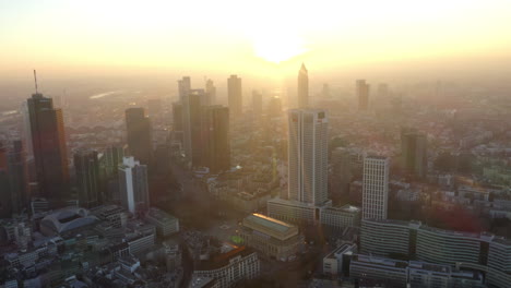 Antena:-Vista-De-Frankfurt-Am-Main,-Horizonte-De-Alemania-Con-Sunflair-Entre-Rascacielos-En-La-Hermosa-Luz-Del-Sol-Del-Atardecer-En-La-Neblina-De-Invierno