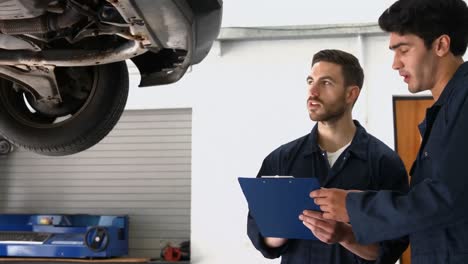 Handsome-mechanics-overhauling-a-car