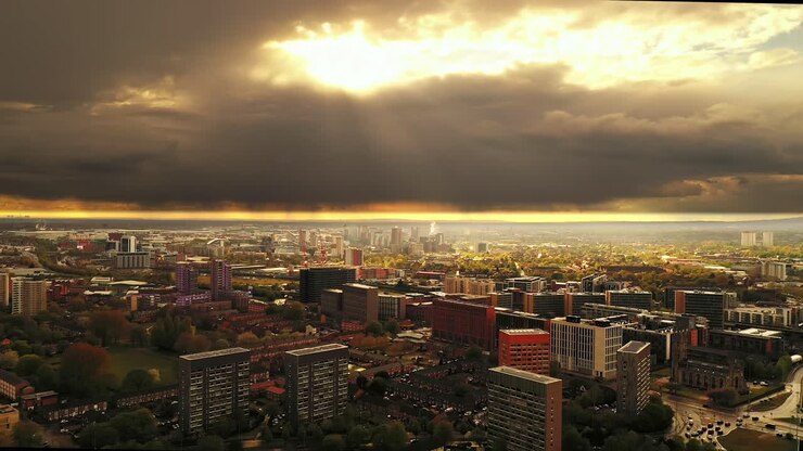 Tomada aérea por drone elevando-se e sobrevoando uma típica cidade suburbana inglesa, Manchester.
