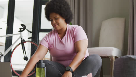 Vídeo-De-La-Sección-Media-De-Una-Mujer-Afroamericana-De-Talla-Grande-Con-Ropa-Deportiva-Preparándose-Para-Hacer-Ejercicio